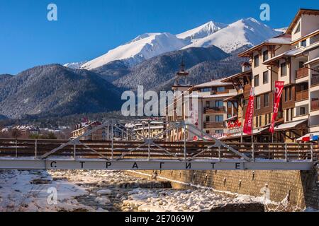 Bansko, Bulgarien - 28. Januar 2021: Fluss Glazne in der bulgarischen Stadt, Hotelhäuser und Schnee Pirin Berge Stockfoto