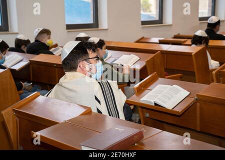 Jerusalem, Israel - 28. Januar 2020: Menschen, die in einer Synagoge beten, tragen Schutzmasken. Stockfoto