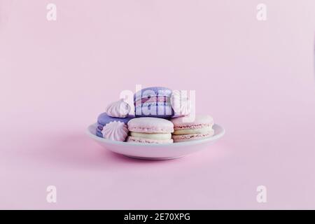 Leckere französische Macarons auf rosa Pastelltönen. Rosa und violette Macarons. Für Text platzieren. Stockfoto