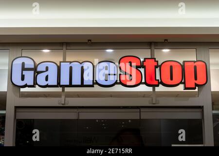 GameStop-Shop vor einem Einkaufszentrum. Großes beleuchtetes Logo, das während der Schließung von Covid-19 leuchtet, während der Einzelhandel geschlossen bleibt. Stockfoto