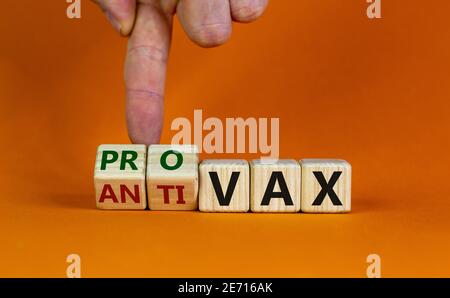 Pro-vax- oder Anti-vax-Symbol. Der Arzt dreht einen Würfel, ändert die Worte „Anti-vax“ in „Pro-vax“. Schöner orangefarbener Hintergrund. Speicherplatz kopieren. Business, medizinische Kov Stockfoto