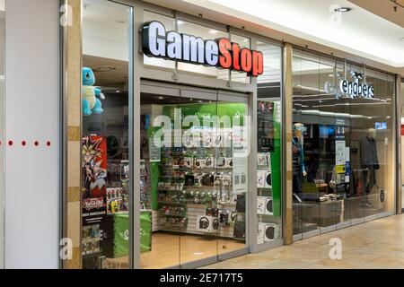 GameStop-Shop vor einem Einkaufszentrum. Großes beleuchtetes Logo, das während der Schließung von Covid-19 leuchtet, während der Einzelhandel geschlossen bleibt. Stockfoto