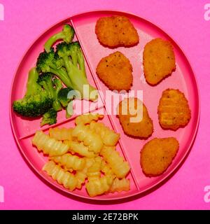 Zu Hause Schule Huhn Nugget Mittagessen auf Tablett mit serviert pommes Frites und Brokkoli Stockfoto