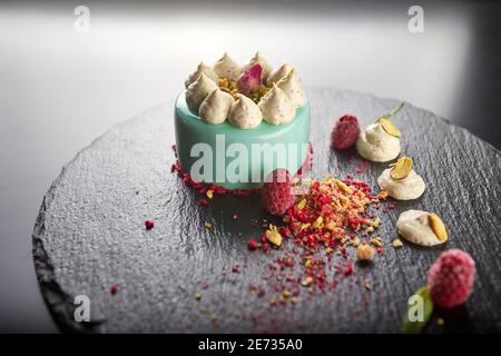 Käsekuchen mit Himbeeren und Nüssen auf schwarzem Hintergrund Stockfoto