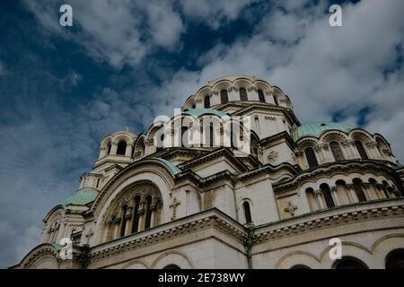 06.01.2021. Sofia. Bulgarien. Prächtige Alexander-Newski-Kathedrale in der Hauptstadt Bulgariens. Bunte Himmel und Parkplatz Autos in der Nähe des Gebäudes. Stockfoto