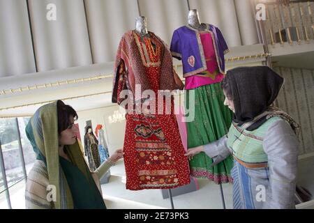 Die iranischen Models Mahsa (L) und Sanaz (R) beobachten am 14. März 2007 auf einer Fashion expo im Sadabad-Palast in Teheran lokal entworfene Kreationen, die gemäß den iranischen Kleiderregeln eine farbenfrohe Kleidung anbieten sollen. Im Iran, wo alle Frauen ihre Körperformen verbergen und den Kopf bedecken müssen, um die islamische Kleiderordnung zu beachten, fördert der Staat einen trendigen, aber islamisch korrekten 'TRO Chic', um Frauen von westlicher Mode abzubringen. Der neue Modus, inspiriert von der langen Geschichte des Landes, ist auf einer Teheraner Modenschau zu sehen, die einen nationalen Stil fördern und eine alternative anbieten will Stockfoto