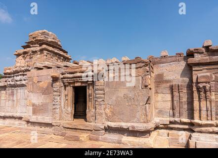 Aihole, Karnataka, Indien - 7. November 2013: Suryanarayana Tempel unter blauer Wolkenlandschaft. Schwer beschädigtes braunes Steingebäude. Stockfoto