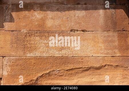 Aihole, Karnataka, Indien - 7. November 2013: Lad Khan Tempel. Nahaufnahme der alten Schrift in braune Steinmauer gemeißelt. Stockfoto