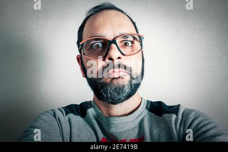 Lustiger Mann mit dem Bart, der Ausdrücke macht Stockfoto