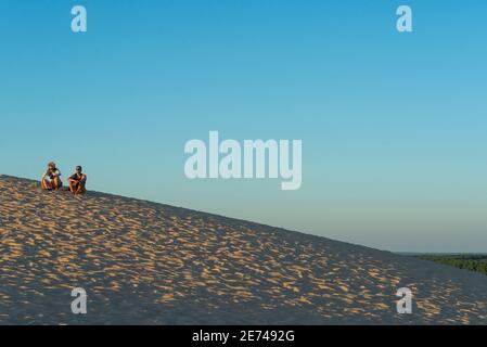 Ein Paar genießt einen romantischen Sonnenuntergang auf der Dune du Pilat, Pyla sur Mer, Landes, Frankreich. Die Düne ist die höchste Sanddüne Europas Stockfoto