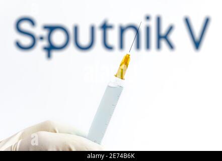 Wien Österreich 29. Januar 2021, Spritze gegen verschwommenes Sputnik V Logo, Sputnik ist der russische Covid19 Impfstoff, der vom Gamaleya Institut entwickelt wurde Stockfoto