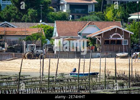 Typische Ferienhäuser in der Nähe von Cap Ferret im Bassin d'Arcachon, Frankreich. Fischrestaurant und Austernzucht Ausrüstung am Strand Stockfoto