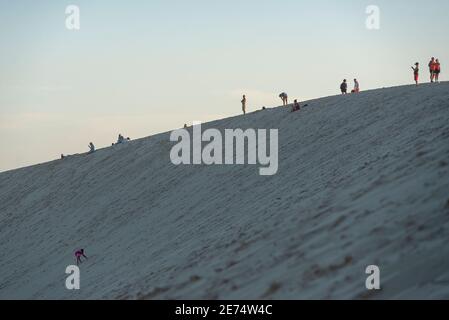 Menschen, die auf der Dune du Pilat, Landes, Frankreich stehen. Diese Sanddüne ist die höchste in Europa und die Menschen versammeln sich dort, um den Sonnenuntergang zu beobachten Stockfoto