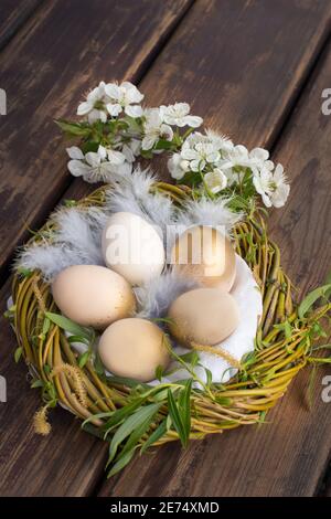 Goldene Eier im Nest, auf dem Holztisch, um ostern zu feiern Stockfoto
