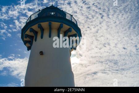 Ikonischer Leuchtturm im Fisherman's Village in Marina Del Rey, Kalifornien, USA, der von der Sonne unter geschwollenen Wolken beleuchtet wird Stockfoto