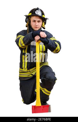 Feuerwehrmann hält Axt und kniet isoliert auf weißem Hintergrund Stockfoto