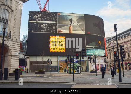 London, Großbritannien. Januar 2021. Im Piccadilly Circus wird die neue Kampagne des NHS "Bleib daheim, schütze den NHS, rette Leben" mit dem Coronavirus gezeigt.die Regierung hat eine starke neue Kampagne gestartet, um die Menschen zu überzeugen, zu Hause zu bleiben, während die Nation darum kämpft, die Pandemie unter Kontrolle zu halten. Kredit: SOPA Images Limited/Alamy Live Nachrichten Stockfoto