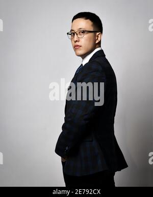 Portrait Profil der asiatischen Geschäftsmann Experte Analyst in offiziellen Anzug, Krawatte und Brille stehen zurück verlassen und gedreht Stockfoto