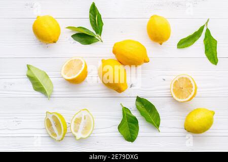 Frische Zitronen und Zitronen Blätter auf weißem Holz- Hintergrund. Stockfoto