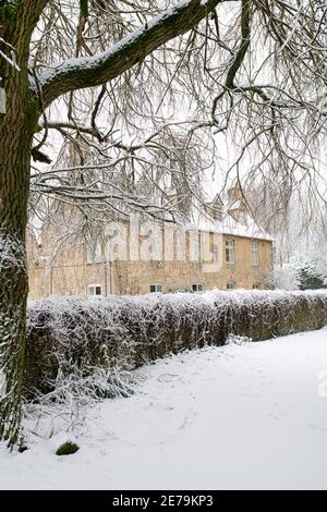 Cotswold Steinhaus in Swinbrook im Schnee. Swinbrook, Cotswolds, Oxfordshire, England Stockfoto