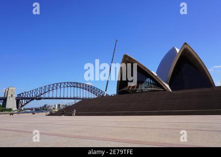 Zwischen Sydney Harbour Bridge und Opera erhebt sich ein Baukran Haus Stockfoto