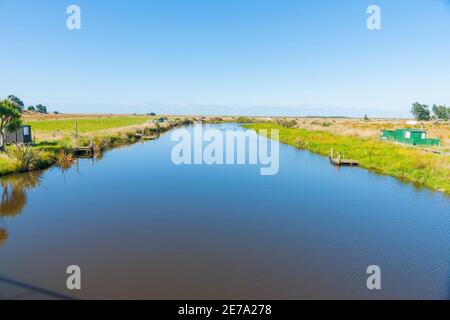 Landschaftlich reizvoller Titiroa Stream in Southland, der zur Küste mit traditionellen Whitebaiter-Hütten am Rand der Südinsel Neuseelands führt. Stockfoto