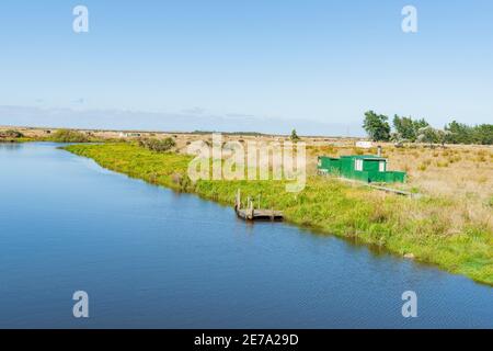 Landschaftlich reizvoller Titiroa Stream in Southland, der zur Küste mit traditionellen Whitebaiter-Hütten am Rand der Südinsel Neuseelands führt. Stockfoto