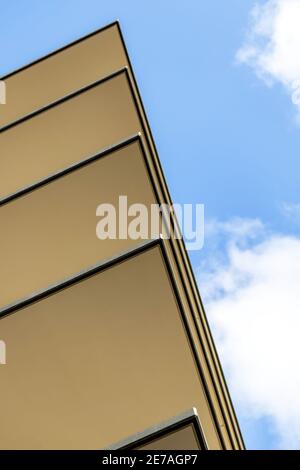 Die Betonecken von 5 Etagen eines neu gebauten Krankenhauses, vor dem Hintergrund eines blauen Himmels, mit ein paar weißen Wolken. Stockfoto