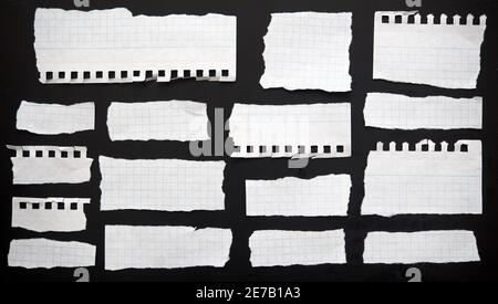 Zerrissene Papiere auf schwarzem Hintergrund Stockfoto