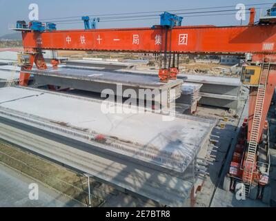 (210130) -- PUTIAN, 30. Januar 2021 (Xinhua) -- Wang Ruifeng betreibt einen Trägerkran, um einen Träger auf einem Trägerbaufeld der China Railway 11 Bureau Group Co., Ltd. In der Stadt Putian, südöstlich der Provinz Fujian in China, am 29. Januar 2021 zu heben. Wang Ruifeng, Jahrgang 1997, arbeitet seit zwei Jahren als Trägerkran-Betreiber. Wang arbeitet hoch über dem Boden und muss mit den Bodenarbeitern zusammenarbeiten, um Kastenträger mit einem Gewicht von über 900 Tonnen genau an den angegebenen Ort zu heben und zu bewegen. Trägerkranbetreiber sind für den Hochgeschwindigkeitsbahnbau unverzichtbar geworden. (Xinhua/Song Weiwei Stockfoto