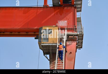 (210130) -- PUTIAN, 30. Januar 2021 (Xinhua) -- Wang Ruifeng steigt die Treppe hinauf, um den Operationsraum des Trägerkrans auf einem Trägerbaufeld der China Railway 11 Bureau Group Co., Ltd. In der Stadt Putian, südöstlich der Fujian-Provinz Chinas, am 29. Januar 2021 zu betreten. Wang Ruifeng, Jahrgang 1997, arbeitet seit zwei Jahren als Trägerkran-Betreiber. Wang arbeitet hoch über dem Boden und muss mit den Bodenarbeitern zusammenarbeiten, um Kastenträger mit einem Gewicht von über 900 Tonnen genau an den angegebenen Ort zu heben und zu bewegen. Trägerkranbetreiber sind für die Hochgeschwindigkeitsbahnkonstruktion unverzichtbar geworden Stockfoto