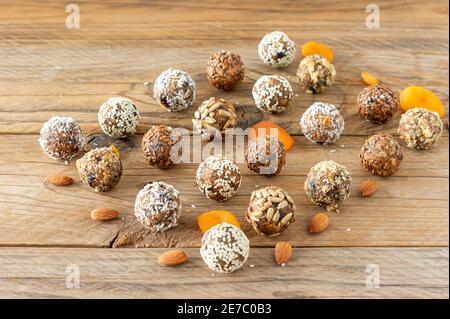 Energy Protein Bälle mit gesunden Zutaten auf Holztisch. Hausgemachte Datteln, Mandel, Flachs und Samen Stockfoto