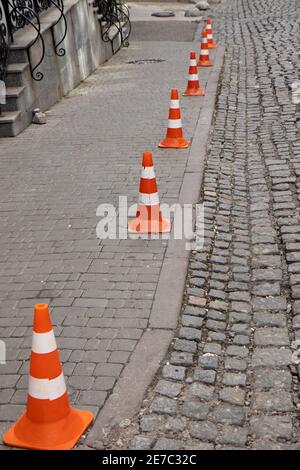 Verkehr Kegel bleiben auf Pflastersteinstraße. Begrenzung des Parkplatzes. Stockfoto