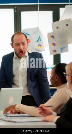 Nervöser Geschäftsmann streitend in Coworking mit Konflikt am Arbeitsplatz beschuldigt schlechte Arbeit Inkompetenz Fehler. Rügen erfolglose Ergebnisse und Rivalität Konzept. Stockfoto