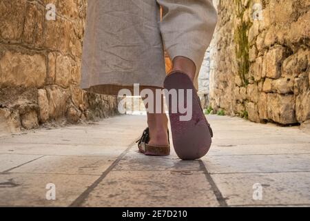 Detail Aufnahme der weiblichen Beine tragen bequeme Reise Sandalen Spaziergang auf alten mittelalterlichen Kopfsteinpflaster Straße dring Sightseeing City Tour. Reisen, Tourismus Stockfoto