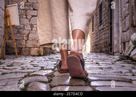 Detail Aufnahme der weiblichen Beine tragen bequeme Reise Sandalen Spaziergang auf alten mittelalterlichen Kopfsteinpflaster Straße dring Sightseeing City Tour. Reisen, Tourismus Stockfoto