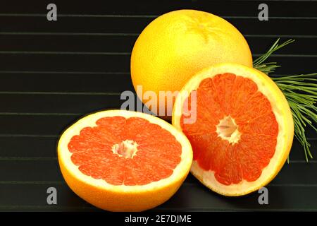 Zitrusfrüchte. Schneiden Sie Grapefruit Nahaufnahme auf einem schwarzen Hintergrund. Stockfoto