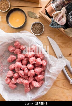 Draufsicht auf viele Wurstscheiben, die mit einer Schere auf einem Backpapier geschnitten wurden. Stockfoto