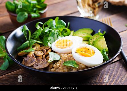 Frühstück Haferbrei Haferbrei mit gekochtem Ei, Avocado und gebratenen Pilzen. Gesunde, ausgewogene Ernährung. Stockfoto