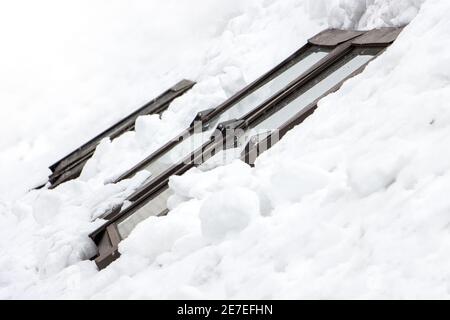 Die verschneite Dach mit Fenster des Hauses. Schiebedächer im Winter. Stockfoto