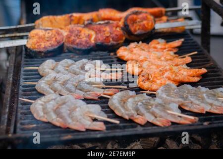 Kochen Tiger Garnelen, Garnelen und Lachs Spieße auf Grill - Meeresfrüchte-Konzept Stockfoto
