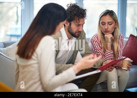 Eine Gruppe junger Geschäftsleute bei einem Treffen in entspannter Atmosphäre diskutieren einige wichtige Daten aus Dokumenten. Menschen, Unternehmen, Meetings Stockfoto