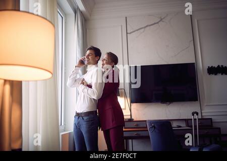 Junges glückliches Paar, das sich auf ein gemeinsames Geschäftstreffen vorbereitet; Business Lifestyle Konzept Stockfoto