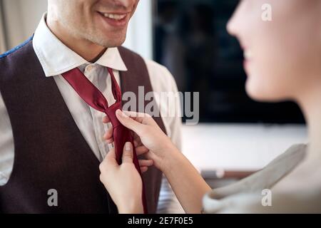 Ein junger Mann auf dem Zimmer bereitet sich auf ein Geschäftstreffen vor und kleidet sich für ein Geschäftstreffen ein. Hotel, Business, Leute Stockfoto