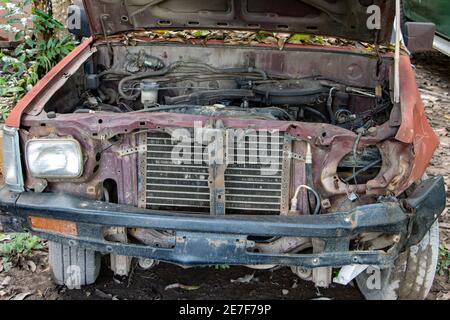 Eine offene Haube eines alten Autos mit Blick auf die Überreste des Motors. Stockfoto