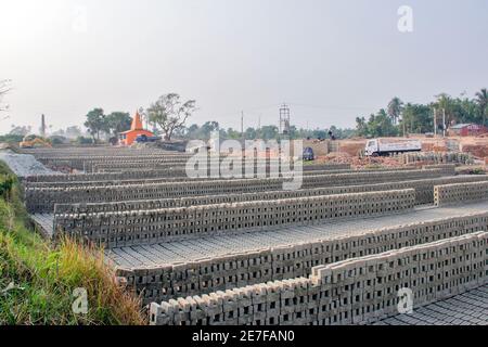 Bilder von Ziegelöfen im ländlichen Bengalen, wo die Arbeit in vollem Gange ist. Ein Vorrat an rohen Ziegeln und fertigen Ziegeln im gesamten Ziegelofen. Stockfoto