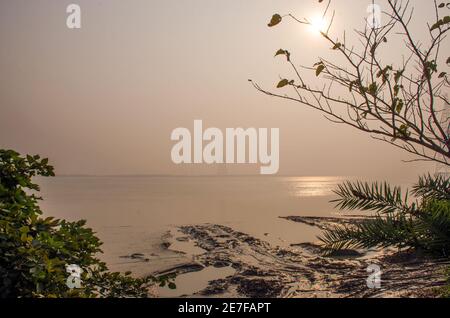 Bild vom Winternachmittag im Diamond Harbour. Wenn die Sonne den Horizont verlässt, geht sie mit ihrem goldenen Glanz am Ufer des Ganges unter. Stockfoto