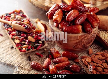 Getrocknete Früchte, verschiedene Nüsse, Beeren und Samen auf einem alten Holztisch. Stockfoto