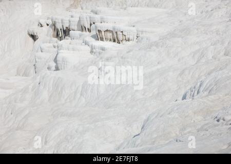 Details von weißem Karbonatmineralgestein, das durch den Wasserfluss in Pamukkale in der Nähe der archelologischen Stätte Hierapolis, Denizli, Türkei, hergestellt wurde Stockfoto