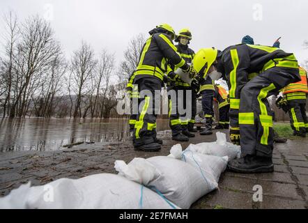 Lindheim, Deutschland. Januar 2021. Feuerwehrleute stapeln Sandsäcke, um Häuser vor der Überschwemmung des Nidder zu schützen. In der Wetterau haben zahlreiche Flüsse ihre Ufer durch den schmelzenden Schnee und die anhaltenden Niederschläge geplatzt. Quelle: Boris Roessler/dpa/Alamy Live News Stockfoto